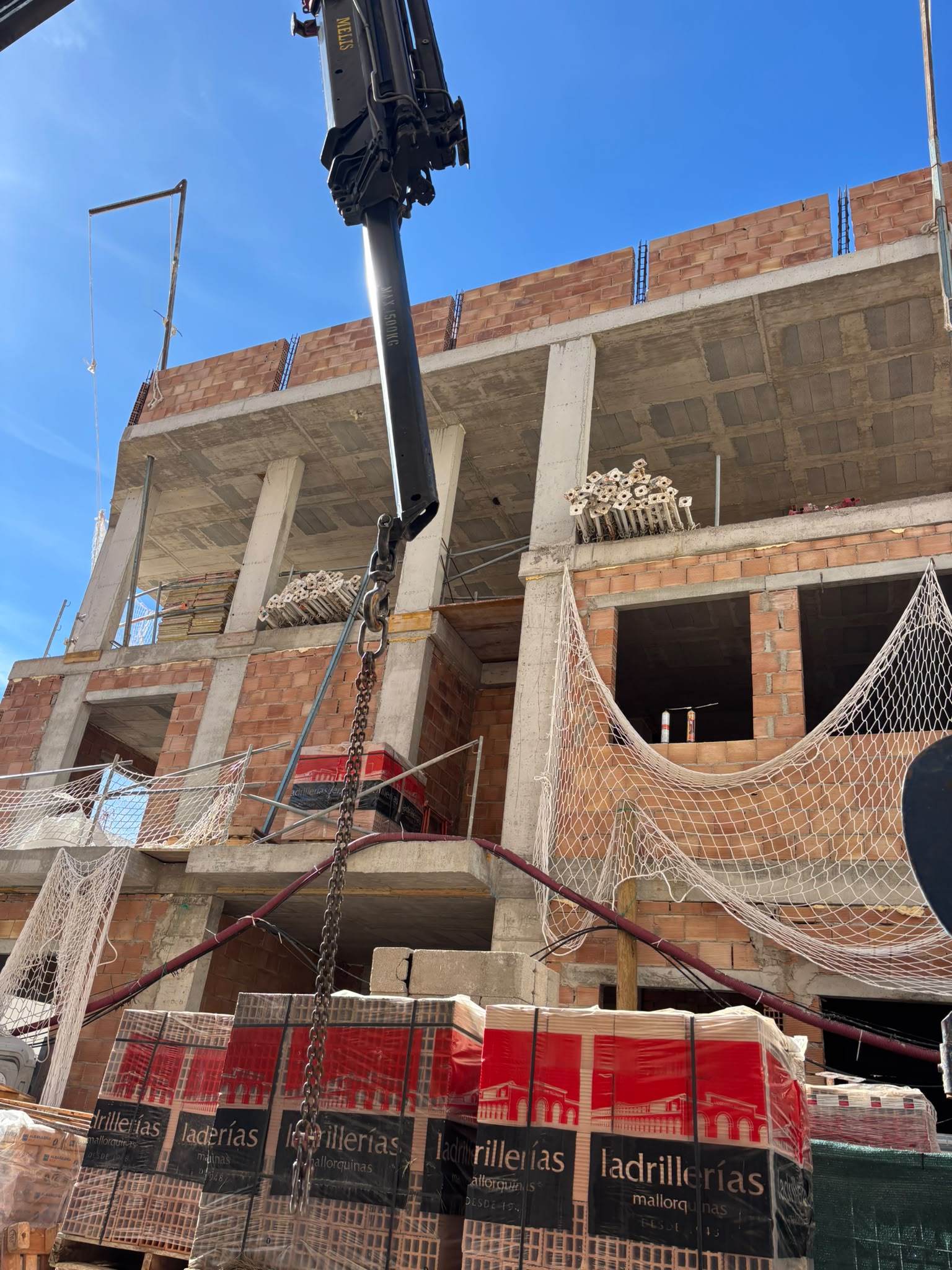 Edificio en construcción con fábrica de ladrillo y grúa