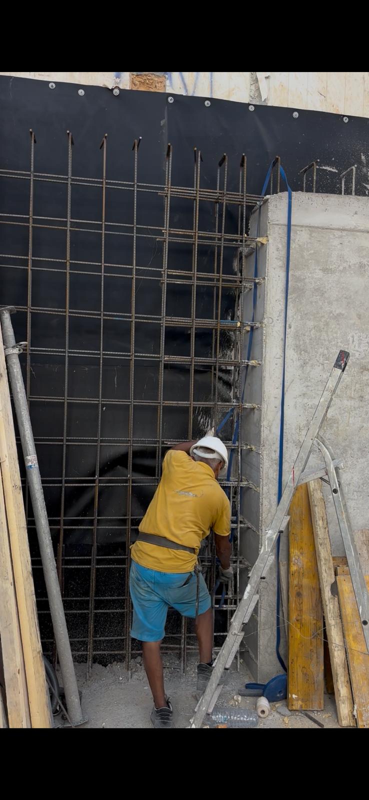 Trabajador de J&A con casco y equipo de alta visibilidad supervisando el forjado